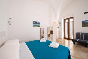a bedroom with a blue bed and a couch at L'Angolo Del Teatro in Galatone