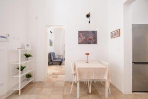 a white room with a table and a kitchen at L'Angolo Del Teatro in Galatone