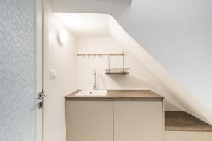 a white kitchen with a sink and a staircase at L'Angolo Del Teatro in Galatone