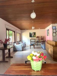 a living room with a table with a vase of flowers at Chalés Casa Rosa in Alto Paraíso de Goiás