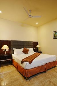 a bedroom with a large bed with a ceiling fan at Central boutique hotel in Morādābād