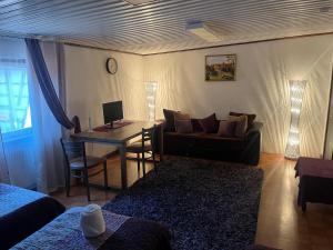 a living room with a couch and a desk with a computer at Sandby in Karlholmsbruk