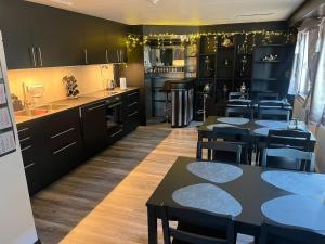 a kitchen with black cabinets and tables and chairs at Sandby in Karlholmsbruk