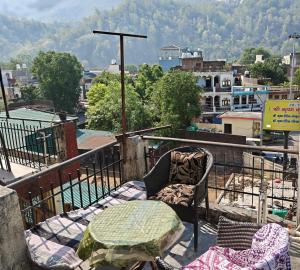 a chair on a balcony with a view of a city at Theprefabnest in Rishīkesh