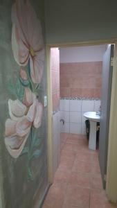 a bathroom with a painting of flowers on the wall at Herberg 1 in De Wildt
