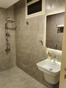 a bathroom with a sink and a shower at أصالة الشروق حائل in Hail +15 photos