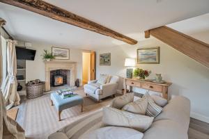 a living room with a couch and a fireplace at Piddle Cottage in Dorchester