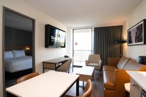 a hotel room with a bed and a living room at Sandman Suites Vancouver on Davie in Vancouver