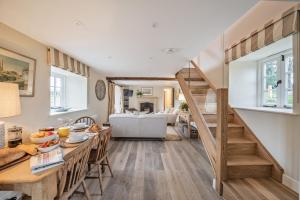 a kitchen and living room with a spiral staircase at Piddle Cottage in Dorchester