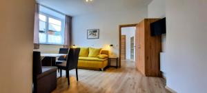 a living room with a yellow couch and a table at Eisenerzer Hof in Eisenerz