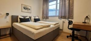 a bedroom with a bed with a desk and a window at Eisenerzer Hof in Eisenerz +95 photos