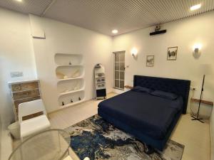 a bedroom with a bed and a table and shelves at Kiki Cottage in Mount Ābu