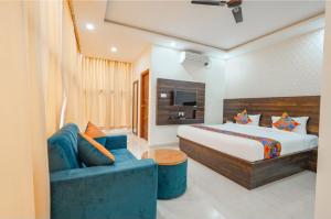 a bedroom with a bed and a blue couch at Hotel Vihara Inn in Bangalore