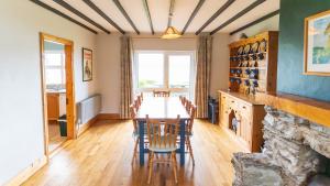 a dining room with a long table and chairs at Blasket Cottage - Portmagee in Lateeve