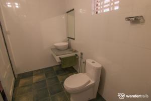 a small bathroom with a toilet and a sink at Whispering Willows in Gūdalūr +36 photos