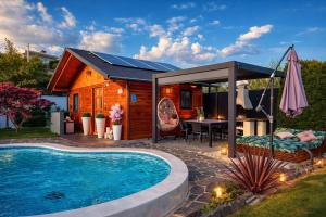 a tiny house with a swimming pool and a pavilion at Aura Luxury Suites Bled in Bled