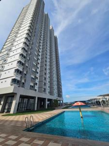 a large building with a swimming pool and an umbrella at CozyHomes at The Peak in Bintulu