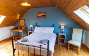 a bedroom with a bed and a chair in a attic at Blasket Cottage - Portmagee in Lateeve