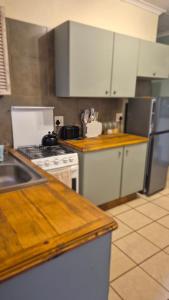 a kitchen with white cabinets and a stove top oven at Herberg 5 in Vosburg