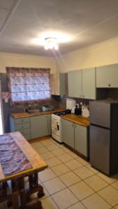 a kitchen with white appliances and a table in it at Herberg 5 in Vosburg +12 photos