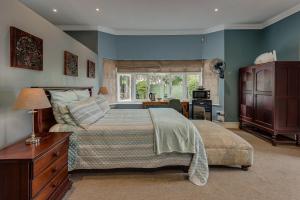 a bedroom with a bed and a desk and a window at Mill Park Executive Suite in Hallack Rock