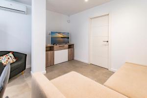 a living room with a couch and a tv at Apartamento Cabrera by Mallorca Infinity in Paguera +20 photos