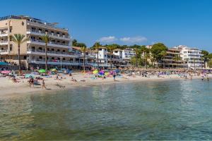 a group of people on a beach with buildings at Apartamento Cabrera by Mallorca Infinity in Paguera