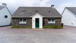 a brick house with a green door at Blasket Cottage - Portmagee in Lateeve