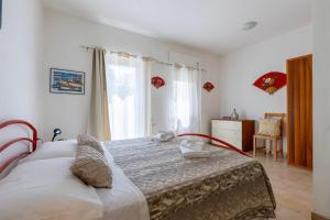 a bedroom with a large bed and a window at Appartamenti Abbaidda 4 in Valledoria +55 photos