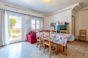 a living room with a table and a red couch at Appartamenti Abbaidda 4 in Valledoria