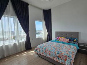 a bedroom with a bed and large windows at CozyHomes at The Peak in Bintulu +5 photos