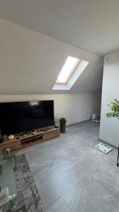 a living room with a large television and a skylight at Apartmán Noel in Soľ