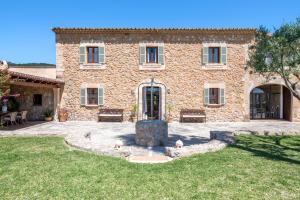 a stone house with a fountain in the yard at Agroturismo Son Bauzanet in Palma de Mallorca