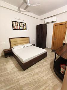 a bedroom with a large bed and a desk at S P Residency in Lucknow