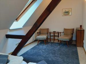 a attic room with two chairs and a table at Die Malche Gäste und Tagungshaus Villa App 13 in Alaunwerk