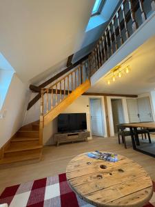 a living room with a tv and a wooden table at Vue incroyable Loire et Chateau in Amboise