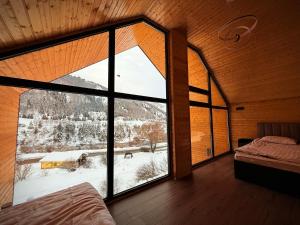 a bedroom with a large window with a view at Capsule & Enesai Hotels Karakol in Karakol