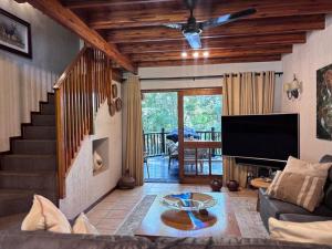 a living room with a couch and a flat screen tv at Hazyview Kruger Lodge in Hazyview