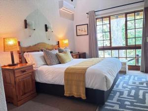 a bedroom with a large bed and a large window at Hazyview Kruger Lodge in Hazyview
