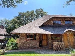 a large brick house with a thatched roof at Hazyview Kruger Lodge in Hazyview