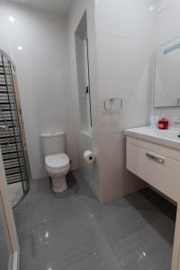 a white bathroom with a toilet and a sink at Sea Steps Marsalforn in Marsalforn +22 photos