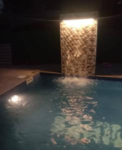 a swimming pool at night with a brick wall at Sahil villa in Alibaug +1 photo