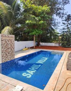 a swimming pool with a sign that says exit at Sahil villa in Alibaug