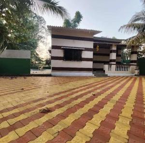 a house with a yellow and white stripes at Sahil villa in Alibaug