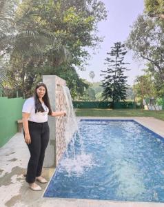 a woman standing next to a water fountain at Sahil villa in Alibaug