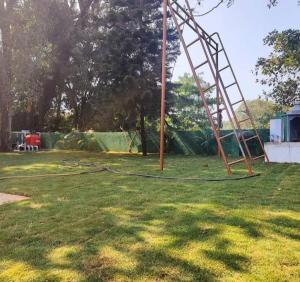 a swing set in a grassy yard with a monkey bars at Sahil villa in Alibaug