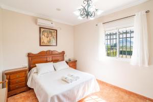 a bedroom with a bed with two towels on it at Cubo's Casa La Peña in Antequera +37 photos