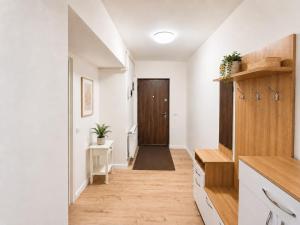 a hallway with white walls and a wooden door at Abel 27 Residence in Bacău