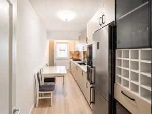a kitchen with white cabinets and a black refrigerator at Abel 27 Residence in Bacău