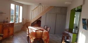 a dining room with a table and a staircase at Gîte Les Galipes in Mareuil-sur-Ay